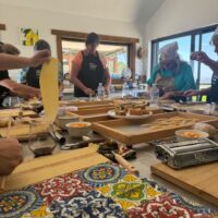 A cooking class making pasta in the Our Italian Table kitchen