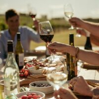 Guests raising their glasses over a long lunch at Our Italian Table